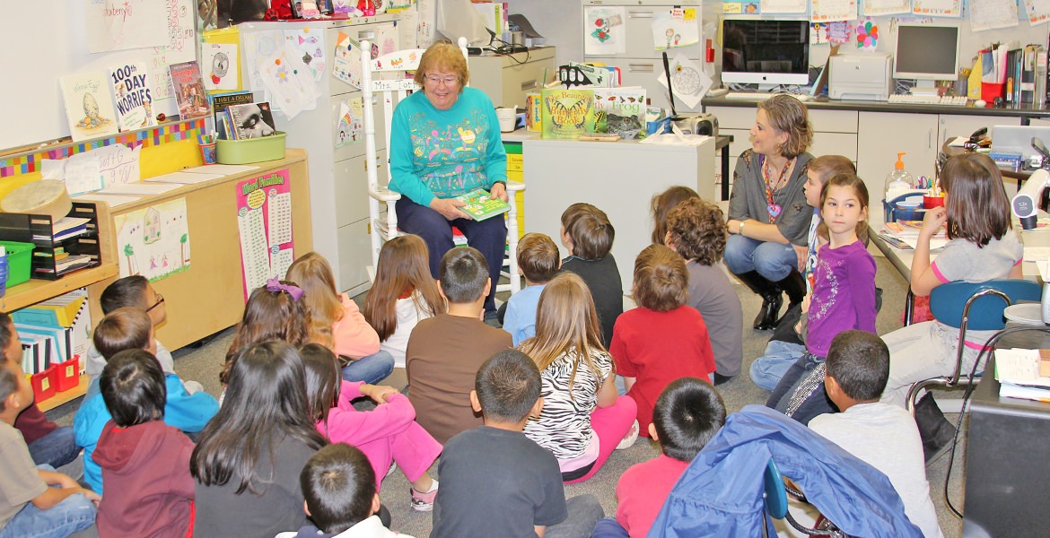 Volunteer reading to a classroom of children